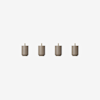 Four small, cylindrical, light brown objects with short vertical brass pegs on top are evenly spaced in a horizontal row against a plain white background.