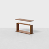 A modern wooden table with a rectangular top hovering above an open rectangular base, set against a plain white background.