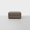A large, rectangular, brown ottoman with a simple, modern design is placed on a light grey floor against a plain white background.