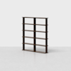 A dark wooden bookshelf with four horizontal shelves and two vertical dividers, creating eight open rectangular compartments, standing on a light gray floor against a plain white background.