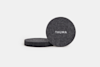 A stack of round, dark gray felt coasters with THUMA printed in white on the top coaster, set against a plain white background.