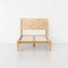 A minimal, light wood single bed frame with a slatted base and a simple, horizontal panel headboard, positioned against a plain white wall and floor background.