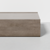 A minimalist rectangular wooden coffee table with a smooth, light brown finish, shown against a white background. Only part of the table is visible in the image.