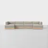 A modern, light gray sectional sofa with clean lines and a low wooden base sits on a smooth, light floor against a plain white background.