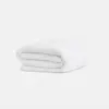 A neatly folded white blanket or comforter is placed against a plain white background.