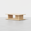 A rectangular wooden coffee table with a minimalist design, featuring an open shelf below the tabletop and a light natural wood finish, placed on a light gray floor against a plain white background.