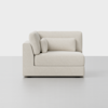 A modern, left-arm chaise lounge upholstered in off-white textured fabric, with three matching cushions, set against a plain, light grey background.