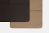 Two rectangular pieces of textured leather, one dark brown and one tan, overlap on a white background. The brown piece is positioned above and to the left of the tan piece.
