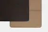 Two rectangular pieces of textured leather, one dark brown and one tan, overlap on a white background. The brown piece is positioned above and to the left of the tan piece.