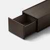 A dark wooden drawer is partially open, revealing its empty interior. The drawer is attached to a matching wooden cabinet against a plain white background.