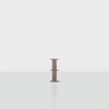 A single, small wooden table or pedestal stands centered in an empty, bright white room with a smooth floor and plain background.