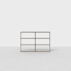 Minimalist wooden three-tier bookshelf with six open rectangular compartments, set against a plain white background and light gray floor.