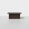 A modern rectangular wooden table with a dark brown finish and a solid base, set against a plain white background.