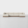 A modern, modular beige sectional sofa with low backs and wooden base, set against a plain white background on a light gray floor.