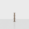 A minimalist wooden bookshelf with four shelves, standing alone in a large, empty, white room with a glossy floor.