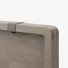 Close-up of a wooden tabletop with rounded edges, featuring a small gray metal clamp or bracket attached to the top edge against a plain white background.