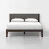 A modern bed with a dark wood frame, upholstered headboard, white bedding, and two pillows, set against a plain white background.