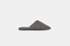 A single gray terry cloth house slipper with a closed toe and open back, displayed in a side profile on a plain white background.