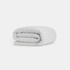 A neatly folded, light gray blanket or duvet placed on a plain white background.