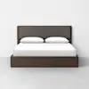 A modern wooden bed frame with a dark brown finish, featuring a rectangular upholstered headboard and two white pillows, neatly made with a white sheet, set against a plain white wall.