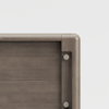 Close-up of the corner of a wooden panel, showing smooth, rounded edges and visible metal screws securing the joint. The wood has a light brown finish and the background is plain white.
