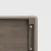 Close-up of the corner of a wooden panel, showing smooth, rounded edges and visible metal screws securing the joint. The wood has a light brown finish and the background is plain white.