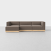 A modern L-shaped sectional sofa with brown upholstery and a light wood base, set against a plain white background on a smooth, light-colored floor.