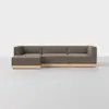 A modern L-shaped sectional sofa with brown upholstery and a light wood base, set against a plain white background on a smooth, light-colored floor.