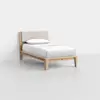 A single wooden bed with a light-colored upholstered headboard, neatly made with white sheets and a pillow, positioned against a plain white wall in a minimalistic room.