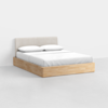 A modern bed with a light wood platform base, a beige upholstered headboard, white bedding, and two white pillows, set against a plain white background.