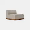 A modern armless lounge chair with light beige upholstery and a wooden base, set against a plain white background.