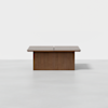 A rectangular wooden dining table with a split down the middle, featuring a solid base and a minimalist design, set against a plain white background.