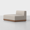 A modern chaise lounge with light beige upholstery, a low backrest on one side, and a wooden base, set against a plain white background.