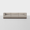 A modern, three-seat modular sofa with light beige upholstery and a dark wooden base, set against a plain white background.