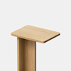 A simple, modern wooden table with a rectangular top and minimalist design, photographed against a plain white background.