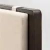 Close-up of a modern bed headboard with a beige upholstered cushion attached to a dark wood frame using a fabric strap, against a plain light background.