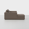 Side view of a modern, brown upholstered sectional sofa with a chaise lounge on the right side, set against a plain white background.