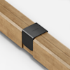 A close-up view of two wooden beams joined together with a black metal bracket labeled THUMA on a plain white background.