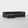 A modern, dark gray L-shaped sectional sofa with low wooden base, set on a light gray floor against a plain white background.