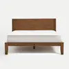 A wooden bed frame with a simple headboard, supporting a white mattress, is shown against a plain white background.