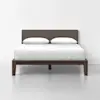 A modern bed with a dark wooden frame, upholstered headboard, and white bedding with two pillows, set against a plain white wall and floor.