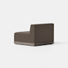 A modern, armless brown upholstered chair with a low backrest and a wooden base, placed on a light gray floor against a plain white background.