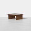 A square wooden coffee table with a flat top and thick, wide legs on each side, shown against a plain white background.