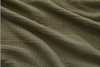 Close-up of soft, textured olive green fabric with visible wavy folds and a subtle crinkled pattern, creating shadows and highlights across the surface.