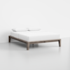 A minimalist wooden bed frame with white bedding and two white pillows, placed against a plain white wall in a clean, modern room with a light-colored floor.