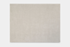A large, rectangular, light beige area rug with a soft, even texture, displayed flat against a plain white background.