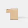 A square wooden box with a light, natural finish sits on a smooth, light gray floor against a plain white background.