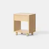 A small, light wood nightstand with a single drawer and an open shelf below, standing on four short cylindrical legs against a white background.