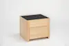 A modern wooden nightstand with light wood finish, featuring two drawers and a dark, textured top surface, set against a plain white background.