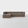 A modern sectional sofa with brown upholstery and a wooden base, arranged in an L-shape on a light gray floor against a plain white background.